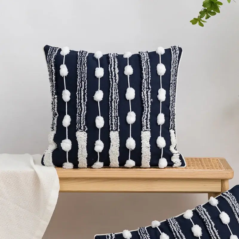 Navy blue cushion cover with white pom-poms and tufted tassels featuring decorbites geometric embroidered accents for bedroom decor