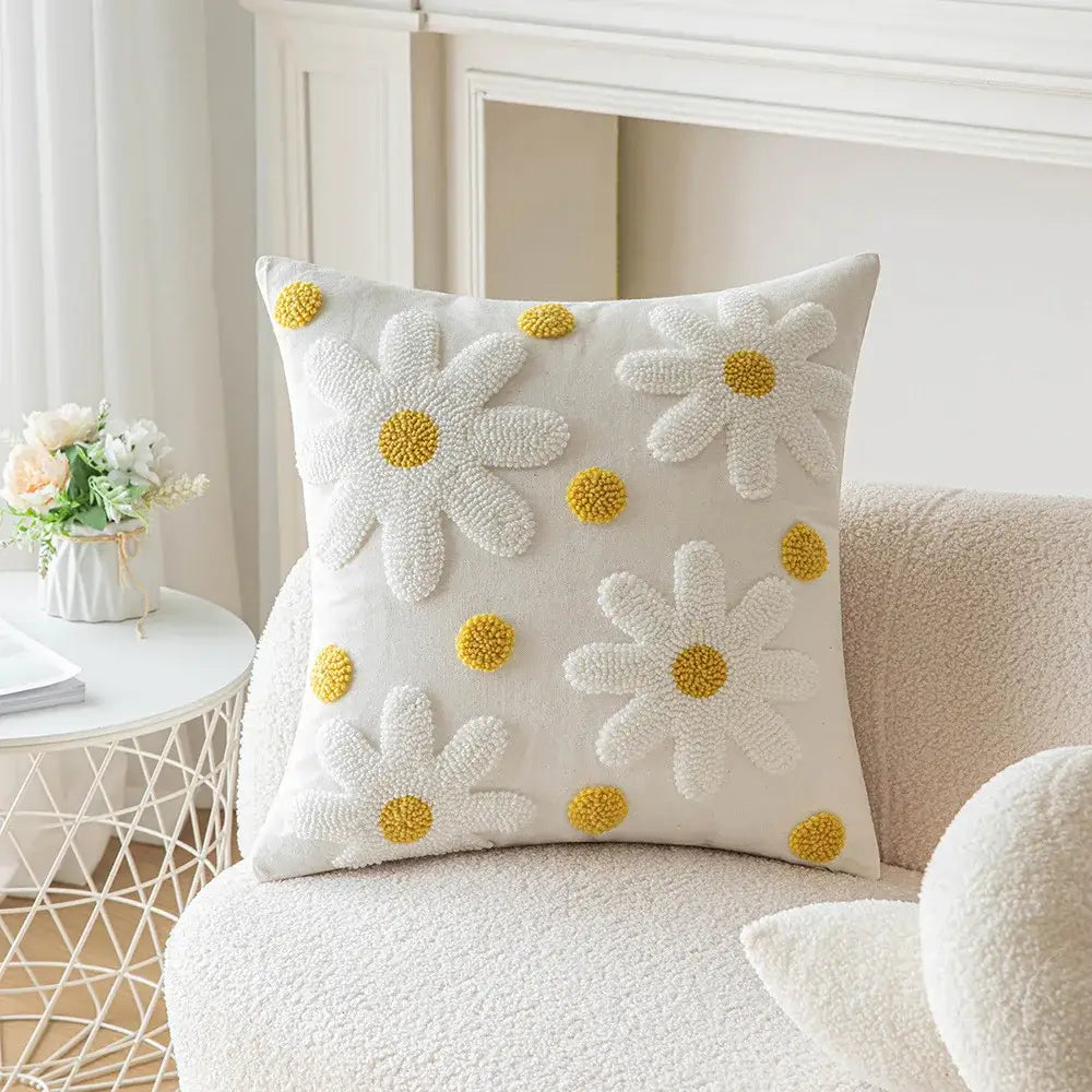 White cushion cover with embroidered daisies and yellow pom-pom centers featuring decorbites geometric embroidery
