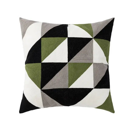 A square cushion cover with decorbites geometric embroidery featuring black, grey, olive green, and white triangles for living room decor