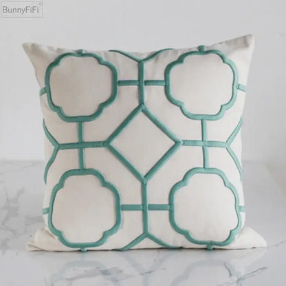 Cream-colored cushion cover with teal decorbites geometric embroidery for yellow and teal living room decor