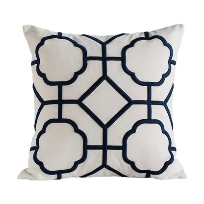 Cream-colored cushion cover with navy blue decorbites geometric embroidery featuring cloud shapes and diamond motifs