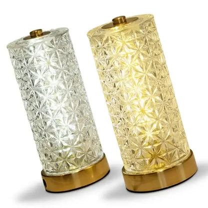 Two decorbites crystal table lamps with faceted starburst pattern in clear and amber glass with gold metal bases