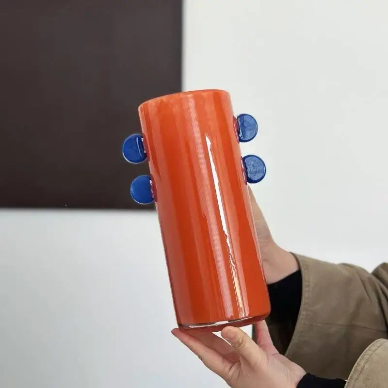 Vibrant orange geometric glass vase with blue color patches and handles for decorbites living room decor