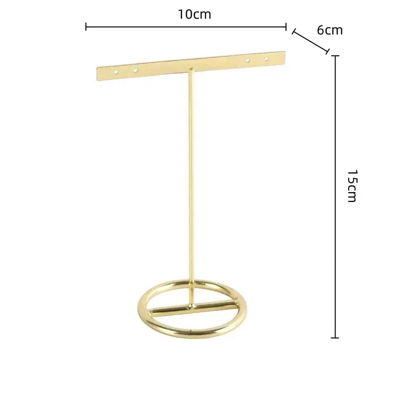 Gold-colored metal geometric jewelry display rack with circular base and horizontal bar for earring organization