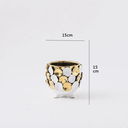 A white ceramic geometric gold leaf relief planter with textured surface and three small feet for living room decor