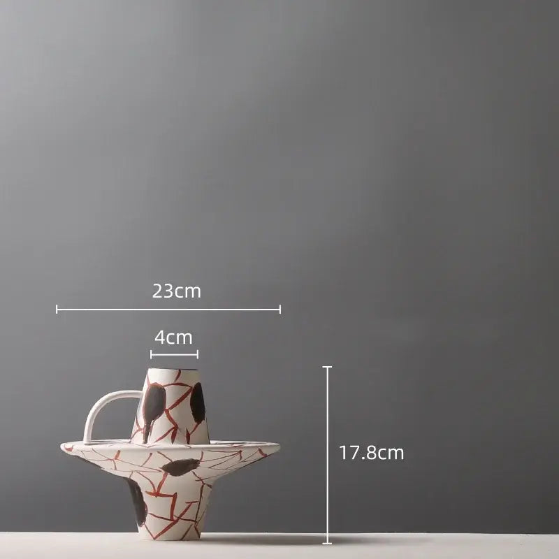 A white ceramic geometric graffiti pitcher with bold red and black crackle patterns for terracotta decorbites living room decor