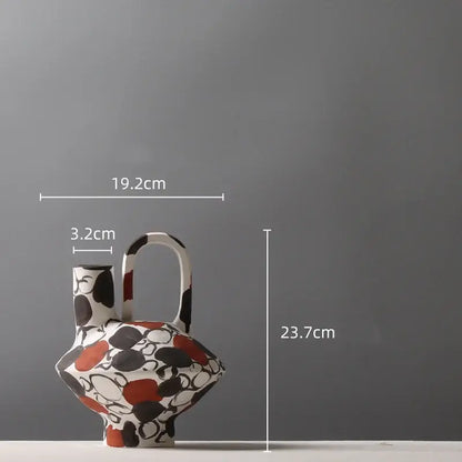 White ceramic geometric graffiti vase with black and terracotta abstract pattern and integrated handle for living room decor