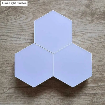 Three interconnected hexagonal led wall lights in soft white with bluetooth app control for modern bedroom decor