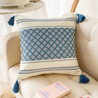 Cream-colored cushion cover with decorbites blue diamond jacquard pattern and matching tassels for living room decor