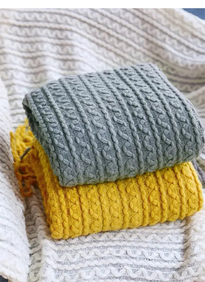 Stacked gray and yellow cable-knit sweaters with ribbed texture complement decorbites geometric knit sofa blanket mustard and off-white throw