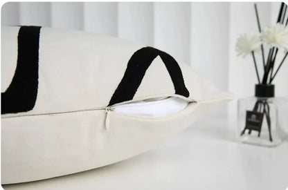 Cream-colored geometric line embroidered pillowcase with bold black abstract patterns and visible zipper closure for decorbites