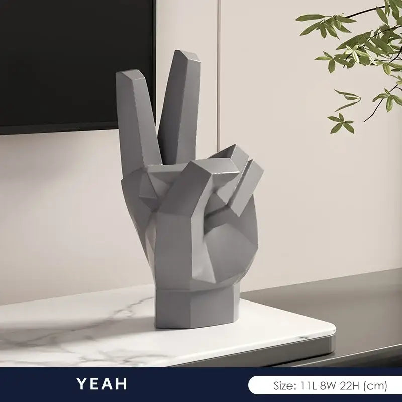Gray geometric hand sculpture with peace sign gesture in matte resin as modern gesture art decor for living room set