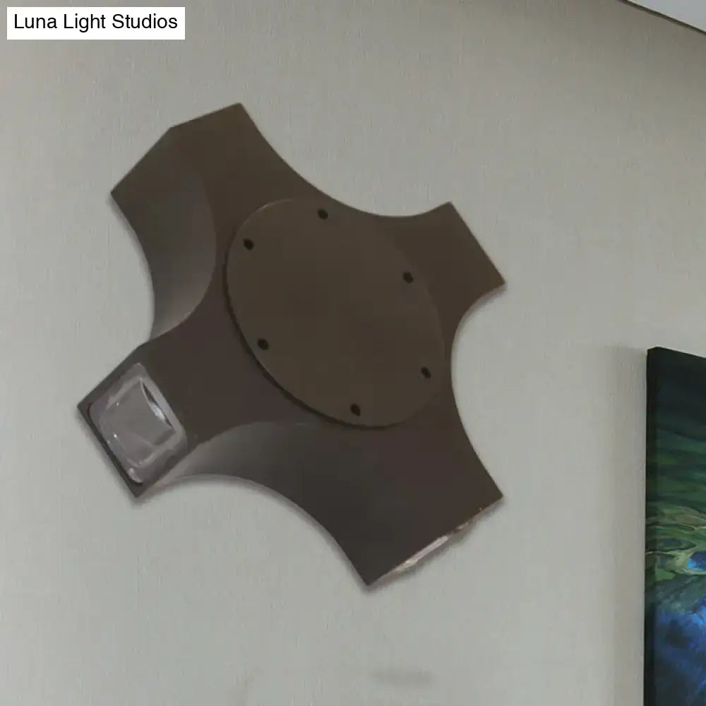 Dark brown four-armed wall-mounted light fixture with circular plate and clear acrylic panel featuring geometric metallic shade