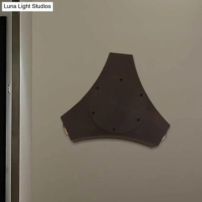 Dark gray triangular wall-mounted speaker with circular center and six holes featuring geometric metallic shade design