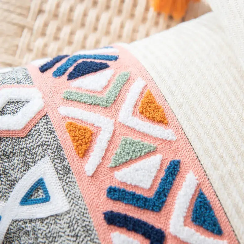 Cozy embroidered cushion cover with vibrant peach navy blue white and olive green geometric pattern and tassels
