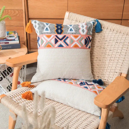 Colorful embroidered cushion cover with navy, orange, and pink geometric patterns and tassels for living room decor