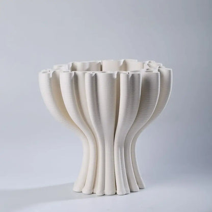 Cream-colored ceramic flower pot sculpture with a fluted design for geometric living room decor