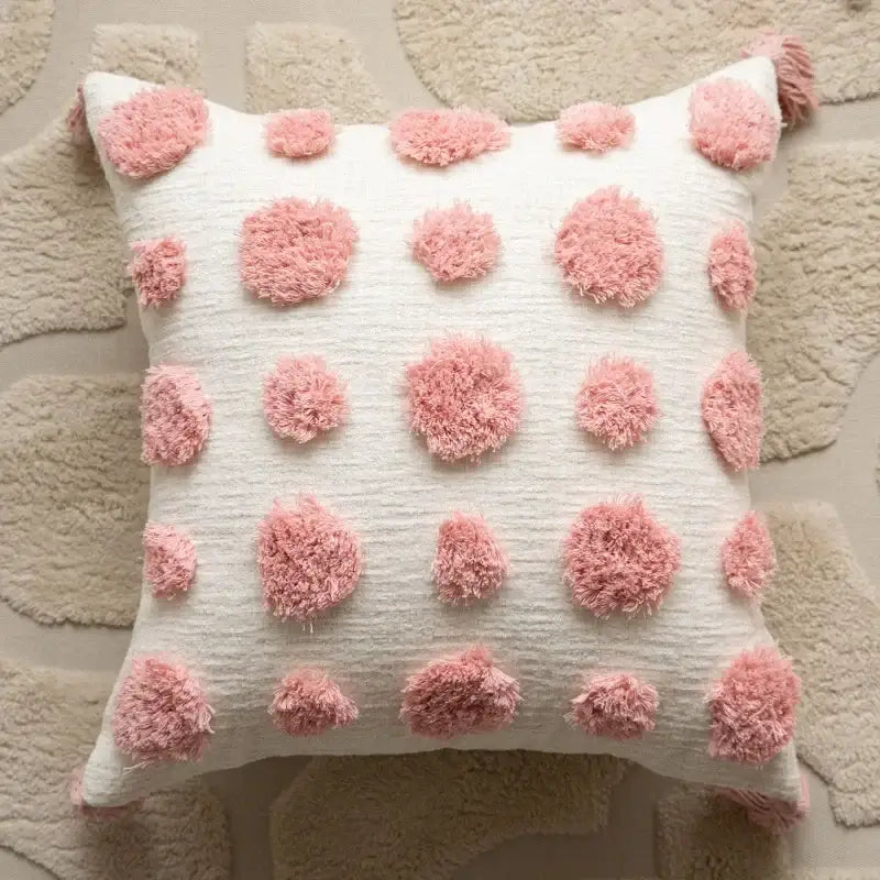 A cream pillow cover with fluffy pink pom-poms in a geometric embroidered style for decorbites cushion covers