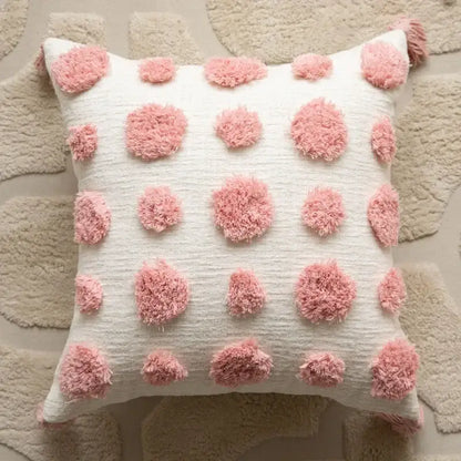 A cream pillow cover with fluffy pink pom-poms in a geometric embroidered style for decorbites cushion covers