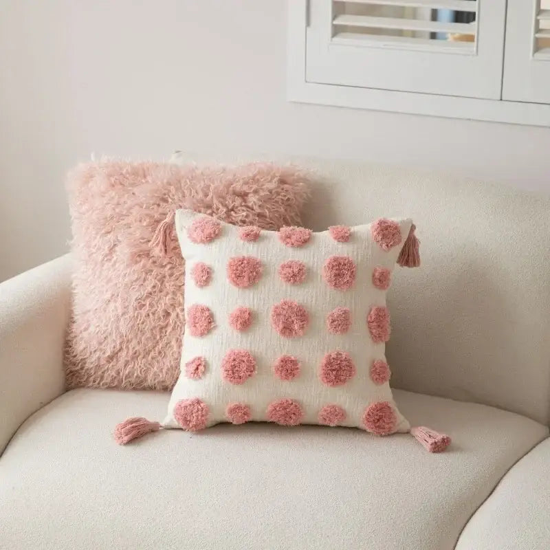 Geometric pink and white embroidered pillow covers featuring off-white fabric with pink pom-poms and tassels decorbites cushion covers
