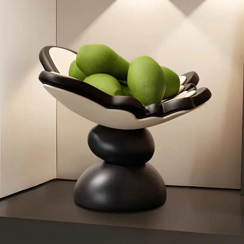 Black and white butterfly geometric resin tray with sculpted petal rim holding green mangoes for dining room storage