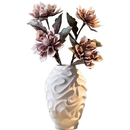 Geometric spiral white ceramic vase with textured wavy surface holding mauve and peach artificial flowers for home decor fruit platter setting