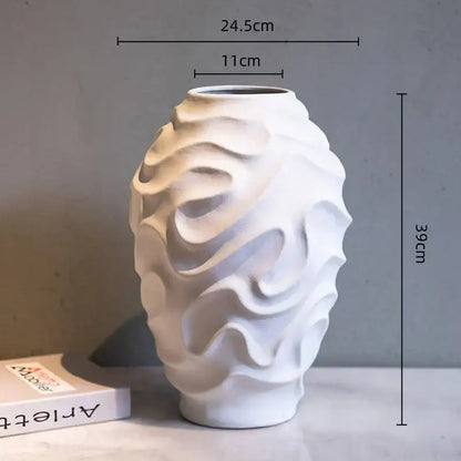 A white ceramic vase with a geometric spiral wavy surface design for home decor and fruit platter display
