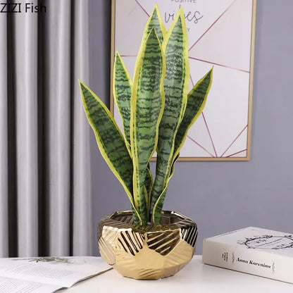 A gold geometric ceramic vase holding a green and yellow-striped snake plant for minimalist decorbites ceramic vase decor