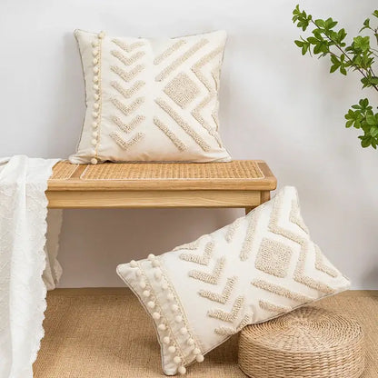 Cream-colored pillow covers with geometric tufted embroidery and pom-pom trim for decorbites geometric tufted decor