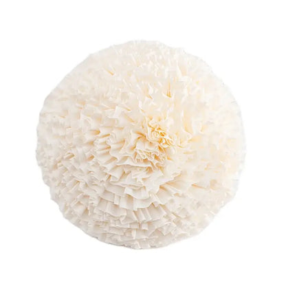 A round off-white paper pom-pom with layered ruffles styled with decorbites geometric tufted navy and white cushion cover decor