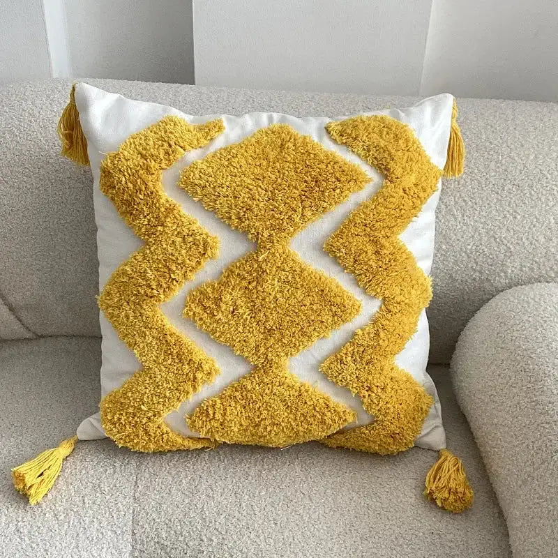 A vibrant yellow and white geometric tufted cushion cover with fluffy tassels for living room decorbites decor