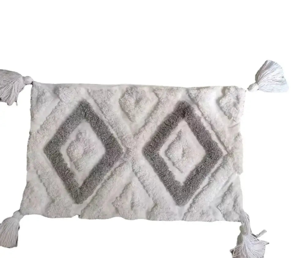 A plush off-white and gray bath mat with a raised diamond pattern and tassels for decorbites geometric tufted style
