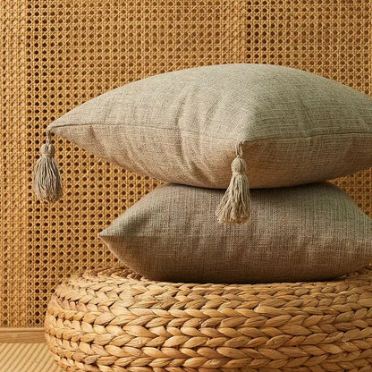 Two stacked beige linen throw pillows with matching tassels complement decorbites geometric tufted cushion cover