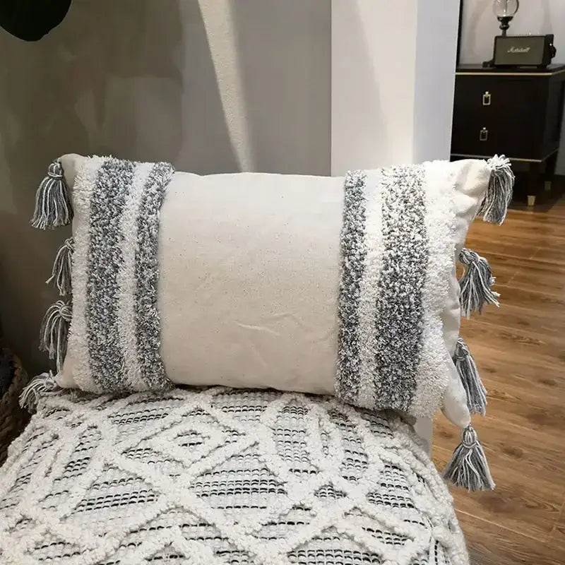 Cream-colored cushion cover with gray and white woven stripes and tassels for decorbites geometric tufted living room decor