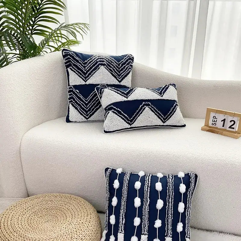 Navy blue and white geometric tufted cushion cover with textured embroidery and pom-pom tassel decorbites geometric tufted design