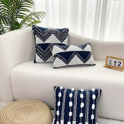 Navy blue and white geometric tufted cushion cover with textured embroidery and pom-pom tassel decorbites geometric tufted design