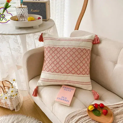 A soft cream cushion cover with woven pink diamond geometric tufted pattern and matching tassels for decorbites decor