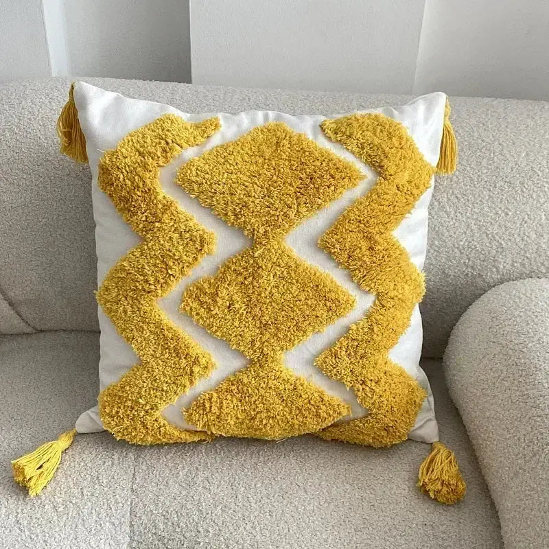 A vibrant yellow and white geometric tufted tassel cushion cover with fluffy corner tassels for beige and gray decorbites decor