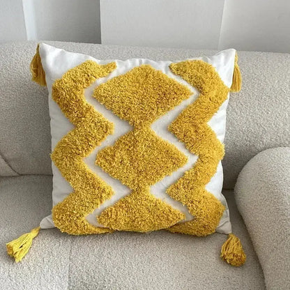 A vibrant yellow and white geometric tufted tassel cushion cover with fluffy corner tassels for beige and gray decorbites decor
