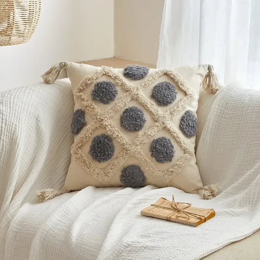 Beige geometric tufted tassel cushion cover with gray pom-pom accents and tassels for living room decor