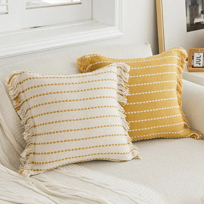 Two rectangular throw pillows with crochet tassels featuring cream and mustard yellow cushion covers by decorbites geometric tufted