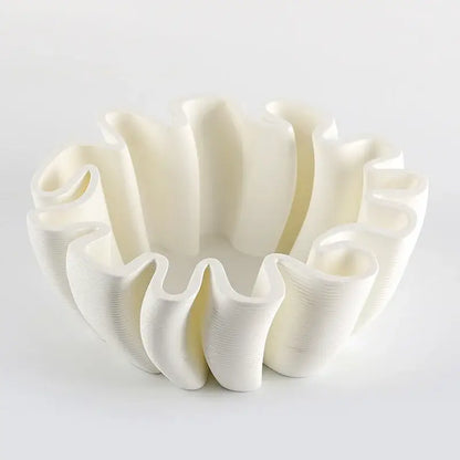 A white 3d-printed fruit plate tray with ruffled wavy rim and vertical ridges for kitchen storage
