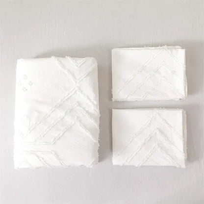 White embroidered handkerchiefs with textured chevron pattern featured on geometric white quilted duvet cover set