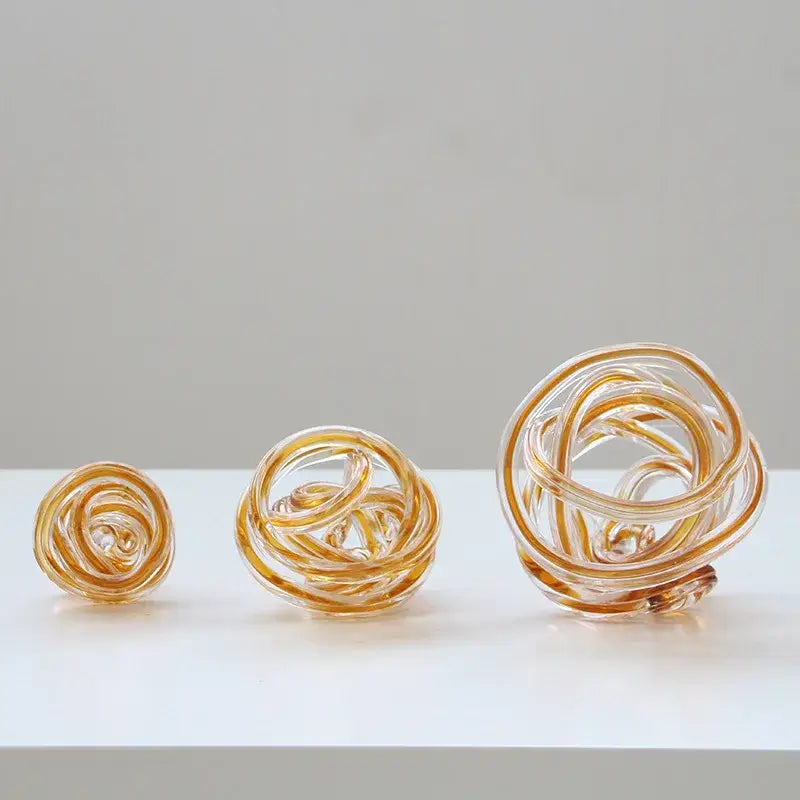 Three amber-tinted geometric wound glass twine spheres with intricate twisted and coiled designs for living room decorbites decor