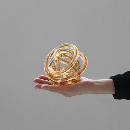 Translucent amber geometric wound glass twine sphere with intricate loops for living room decor by decorbites