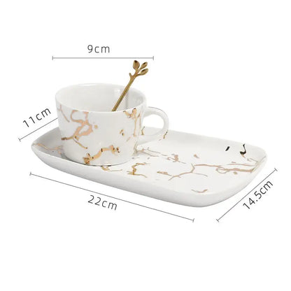 White ceramic cup with gilded marble texture and gold handle with matching golden leaf spoon by decorbites gilded marble