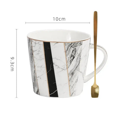 A white ceramic cup with gilded marble texture in black and gold by Decorbites for luxury dining room decor