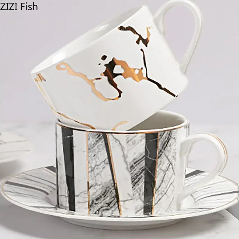 White ceramic cup and saucer set with gilded marble texture gold and black abstract patterns by decorbites