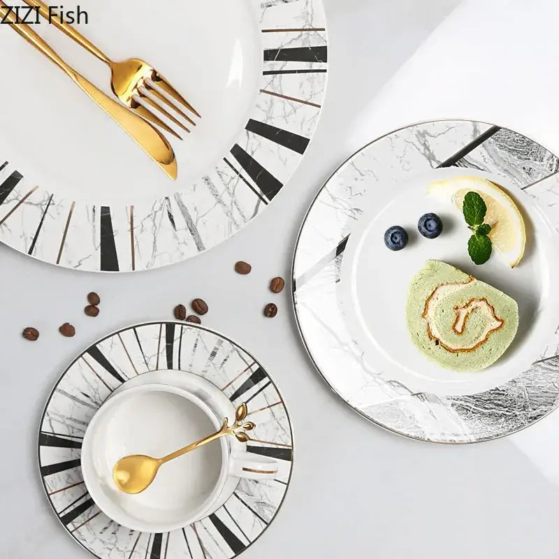 White ceramic plates with black and silver gilded marble texture paired with gold utensils for luxury dining decorbites ceramic cup set