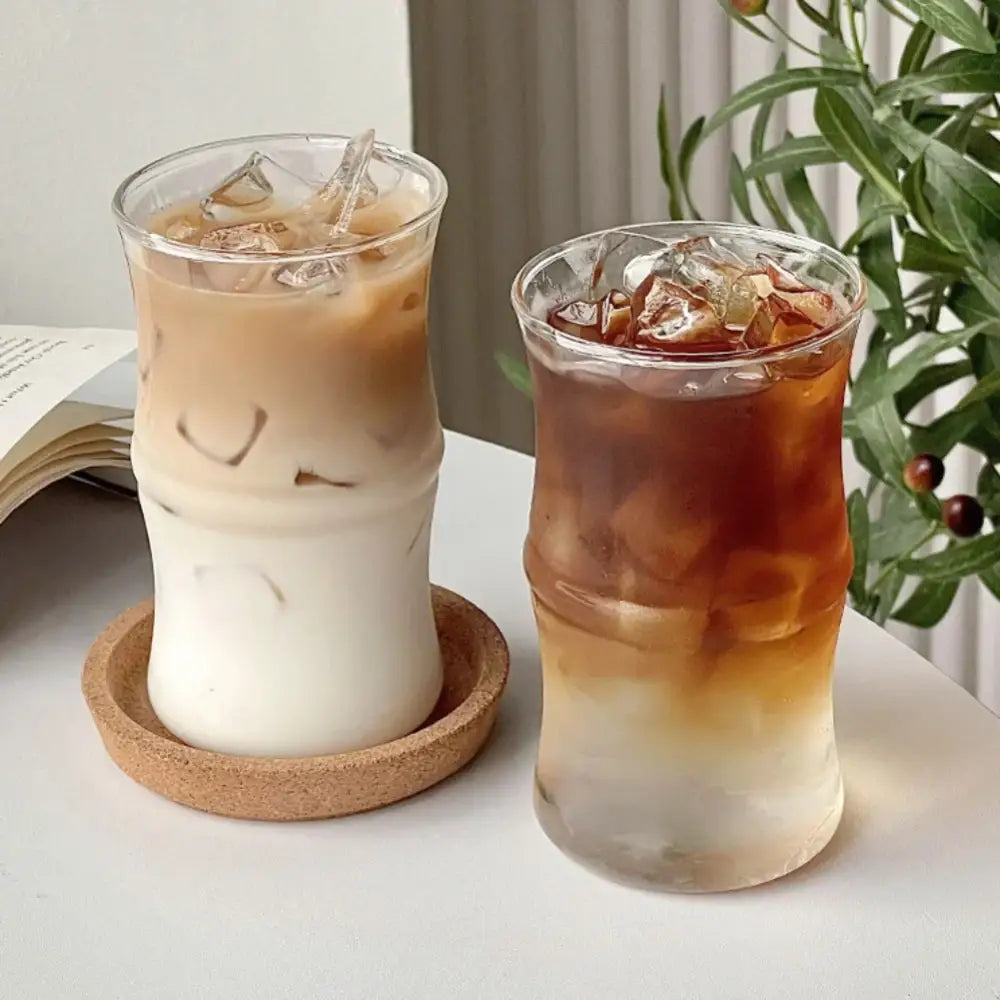 Two clear glass bamboo knot tumblers with ridged design filled with iced coffee and ice cubes for kitchen use